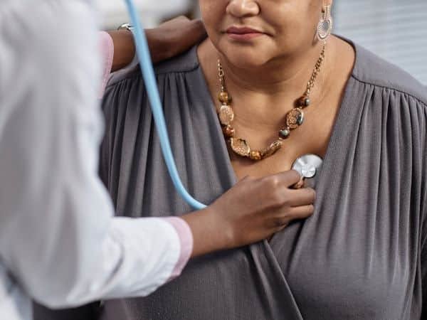 un medico cardiologo a domicilio controlla il battito di una paziente